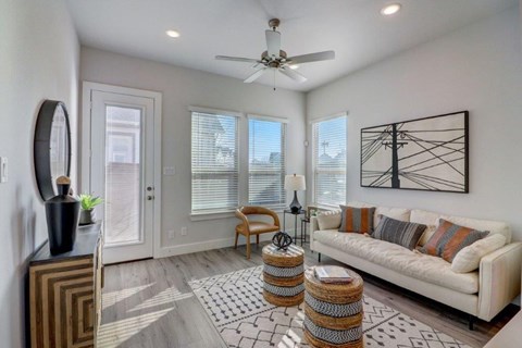 a living room with a white couch and a ceiling fan